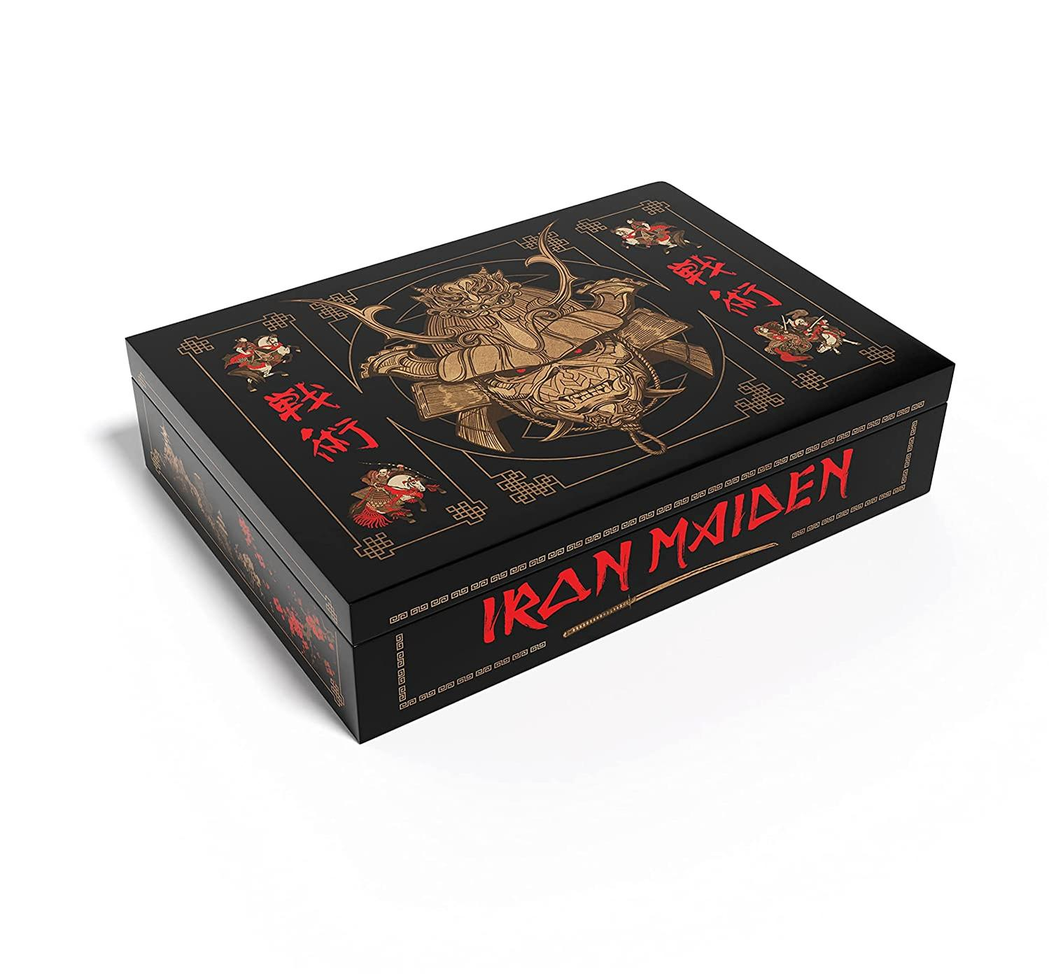 Fekete doboz arany Iron Maiden logóval, piros szöveggel és japán stílusú illusztrációkkal. Fekete háttér.