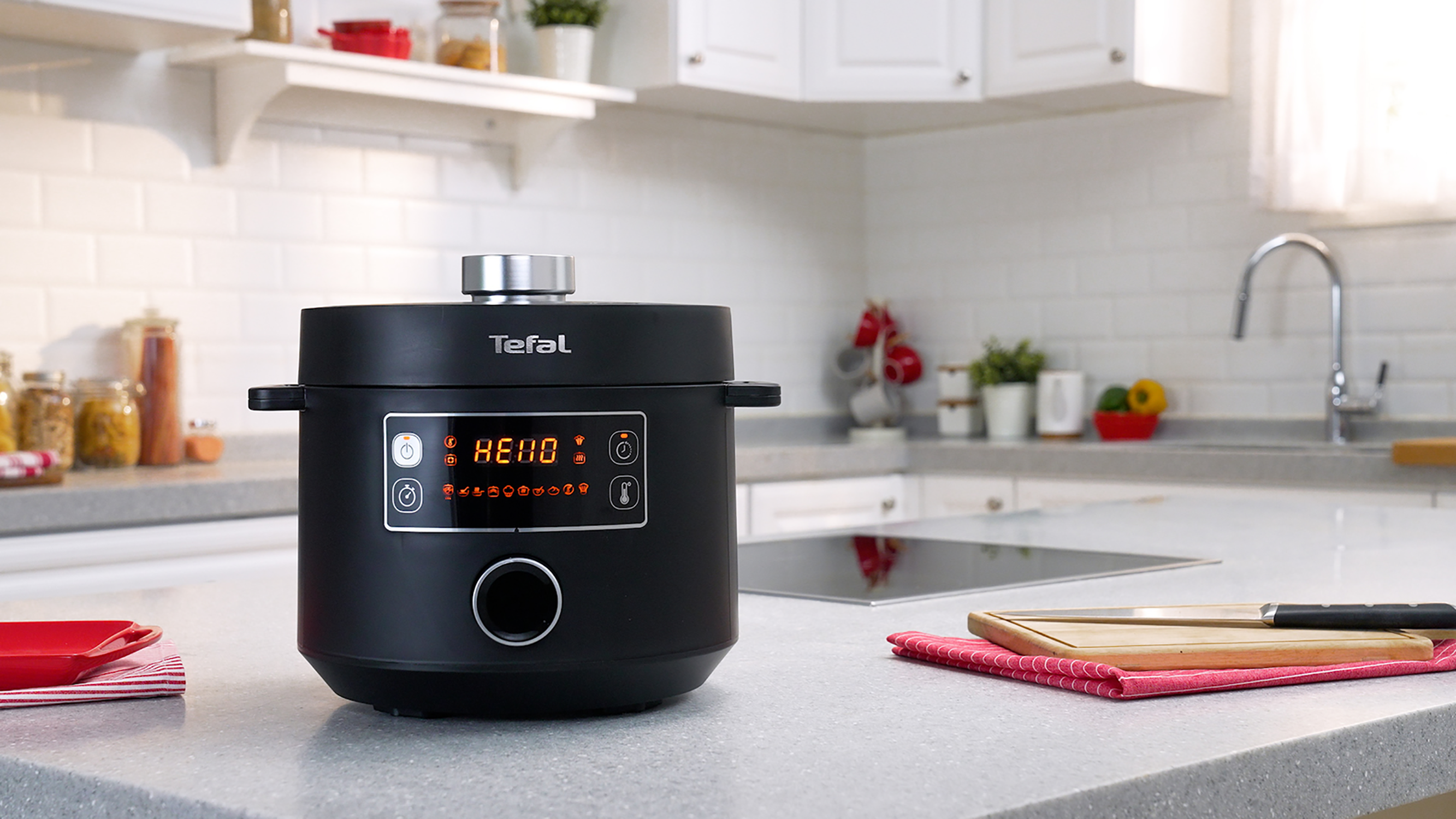 Zwarte Tefal snelkookpan op een aanrecht met andere elementen.