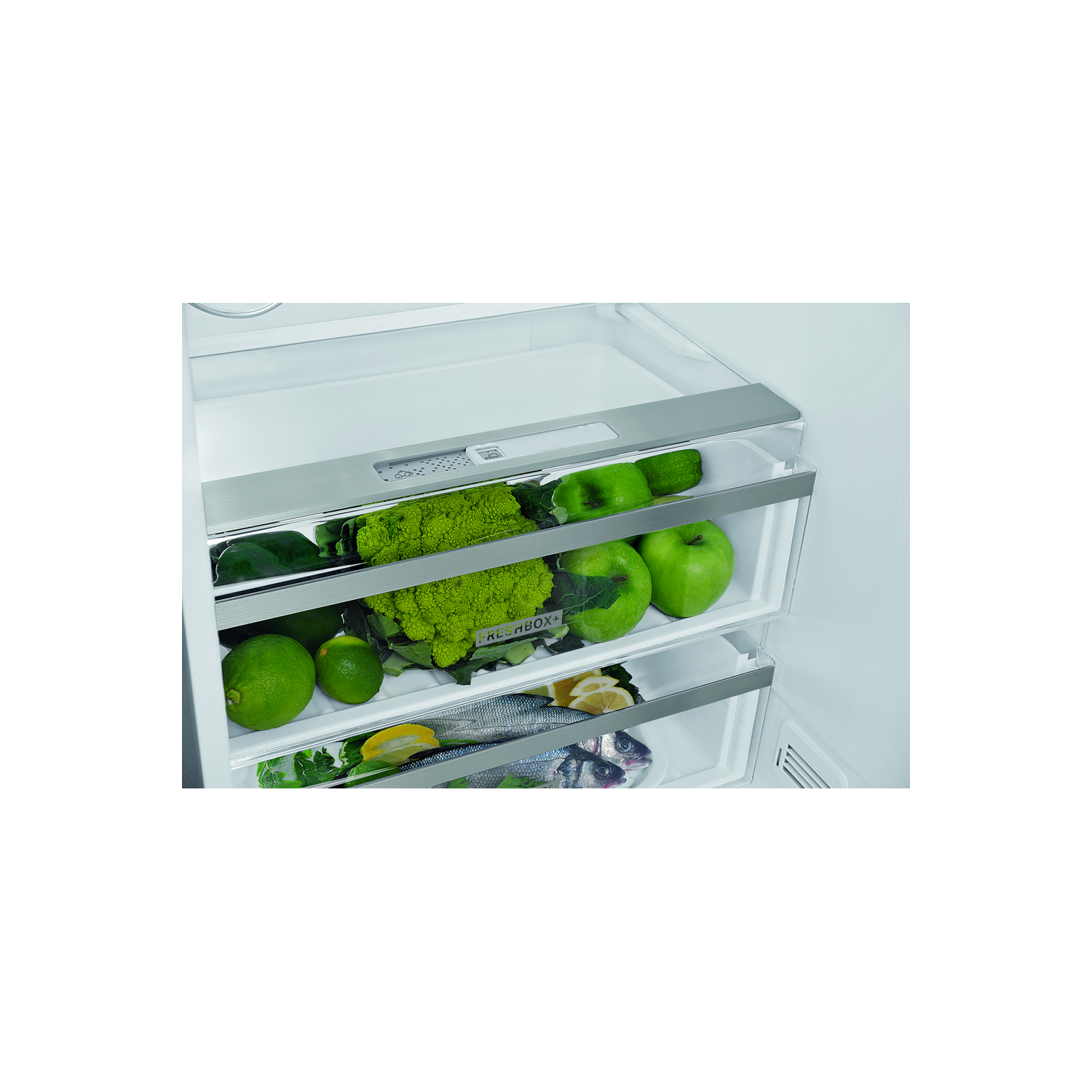 Primer plano de cajones de nevera llenos de productos verdes: limas, manzanas y coliflor.