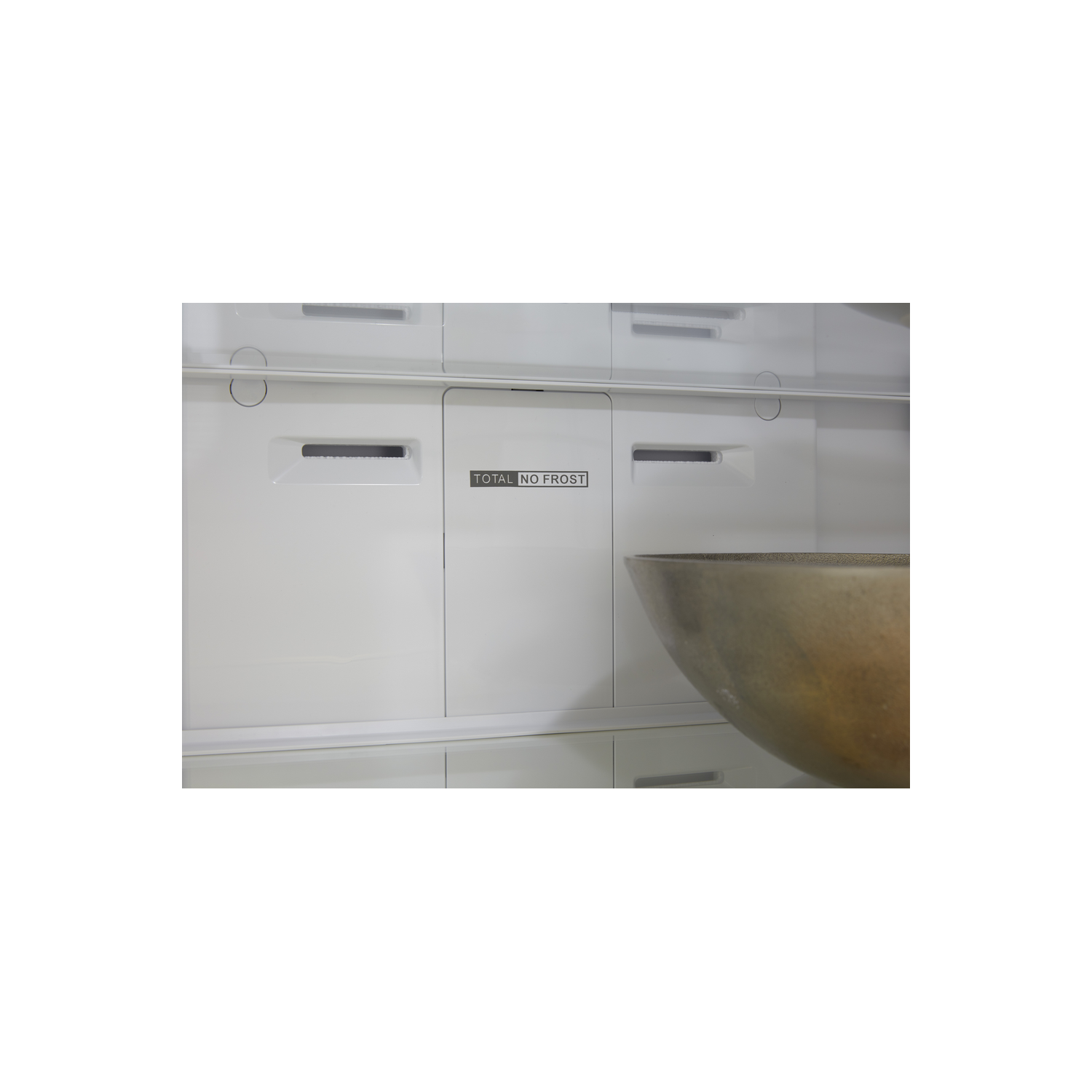 Dentro de un refrigerador, con las palabras "TOTAL NO FROST". Hay un cuenco en la parte inferior derecha.