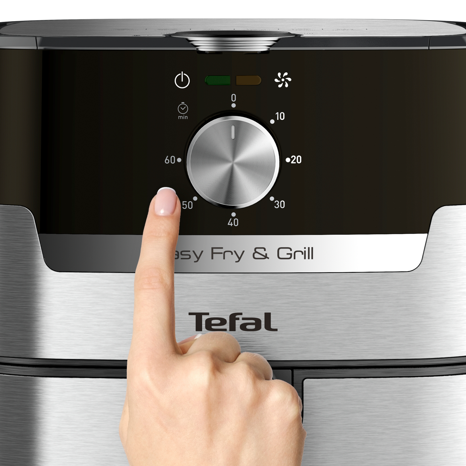 Close-up of an air fryer control panel. A finger touches the timer dial.