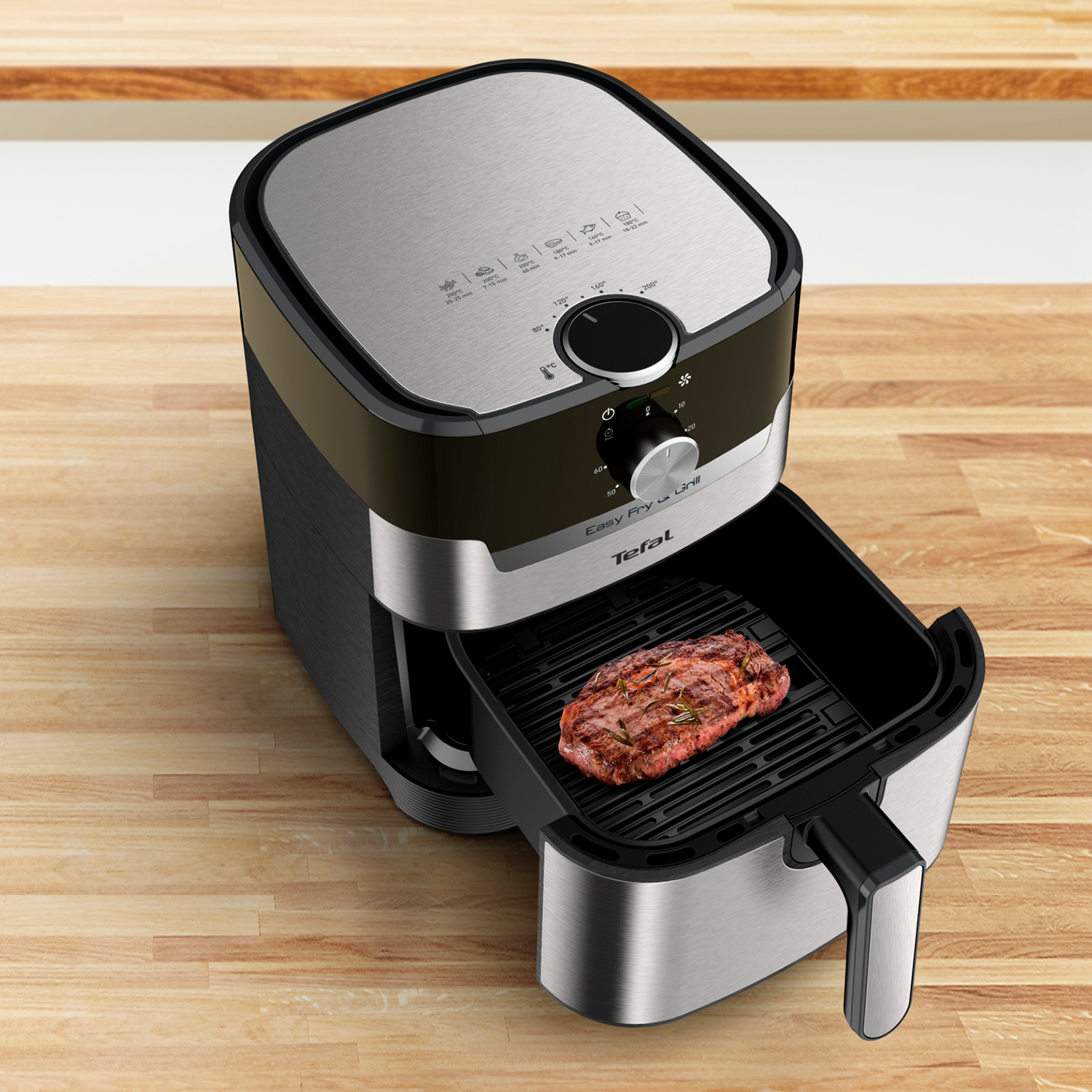 Air fryer with steak inside, on a wooden surface, kitchen background.