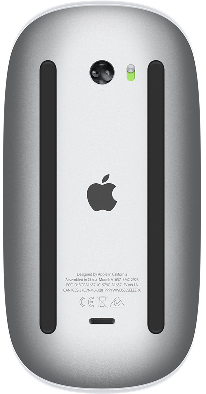 Le dessous d'une souris Apple argentée. Logo Apple visible. Texte et marquages.
