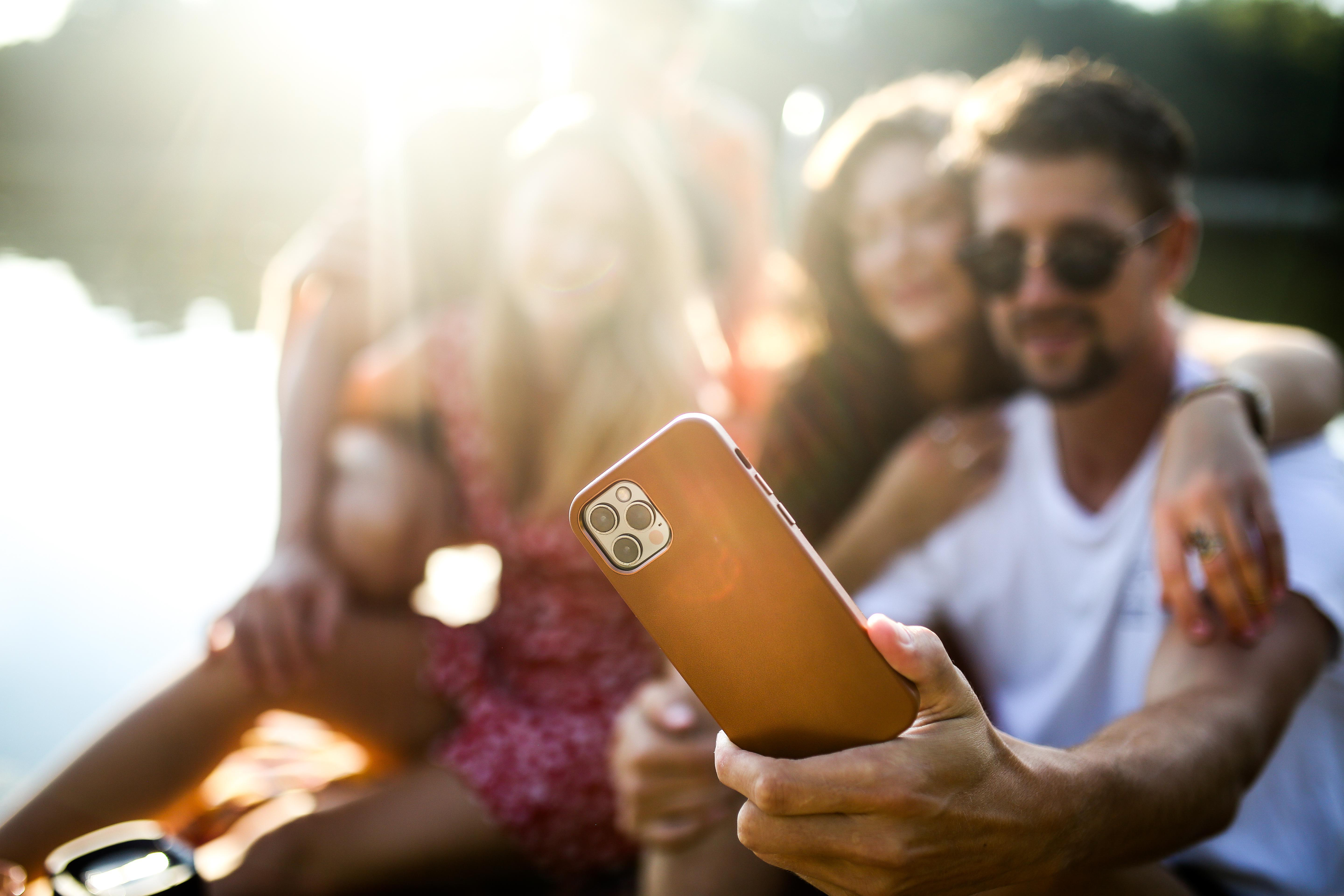 Eine Gruppe von Freunden macht ein Selfie mit einem Telefon.