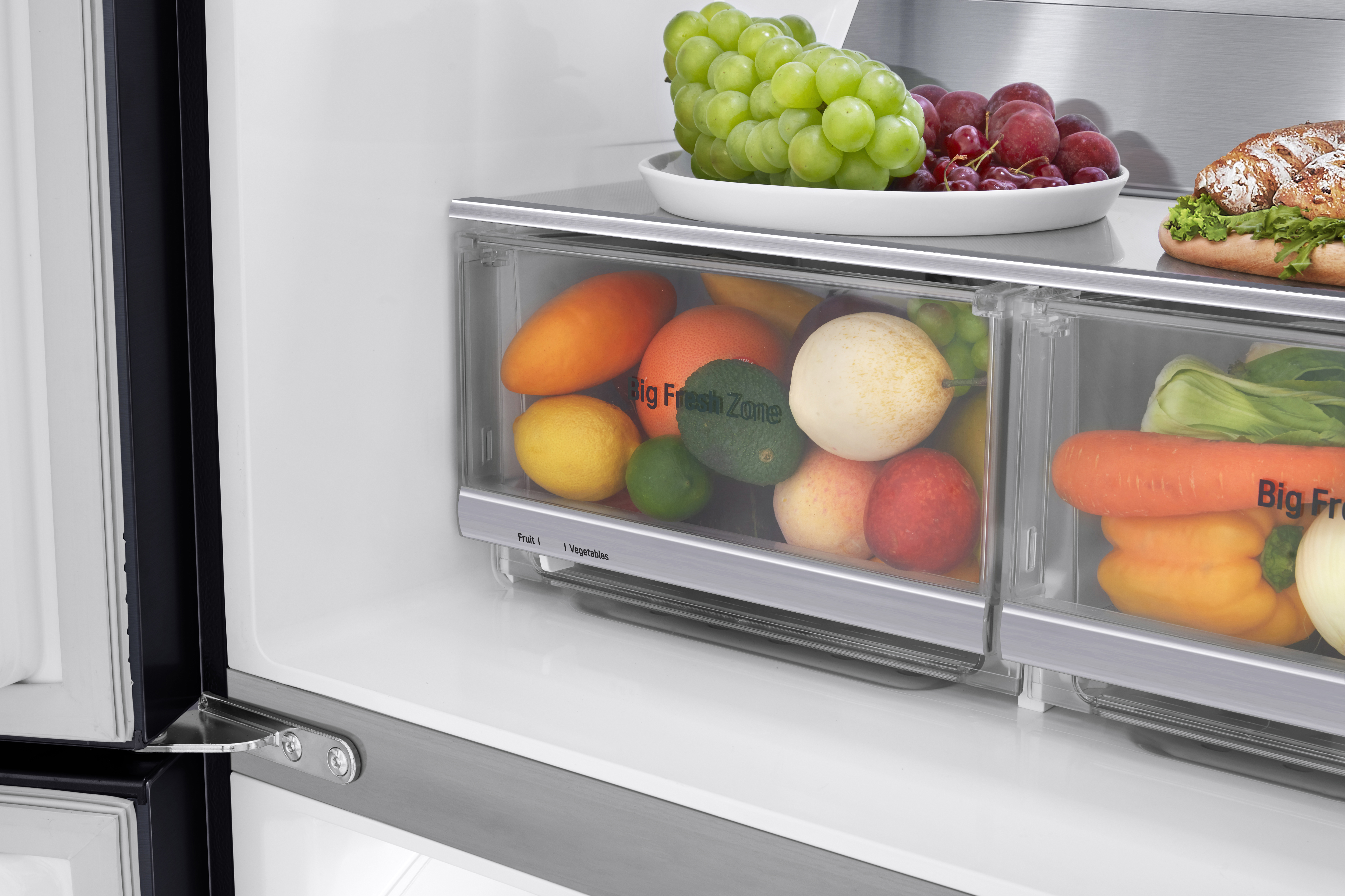 Ein Kühlschrank-Innenraum mit Obst und Gemüse in transparenten Schubladen.