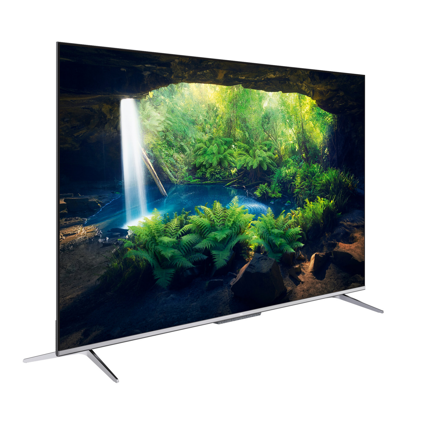 Televisor grande que muestra una escena de bosque con una cascada. Tiene un soporte y marco plateados sobre fondo blanco.