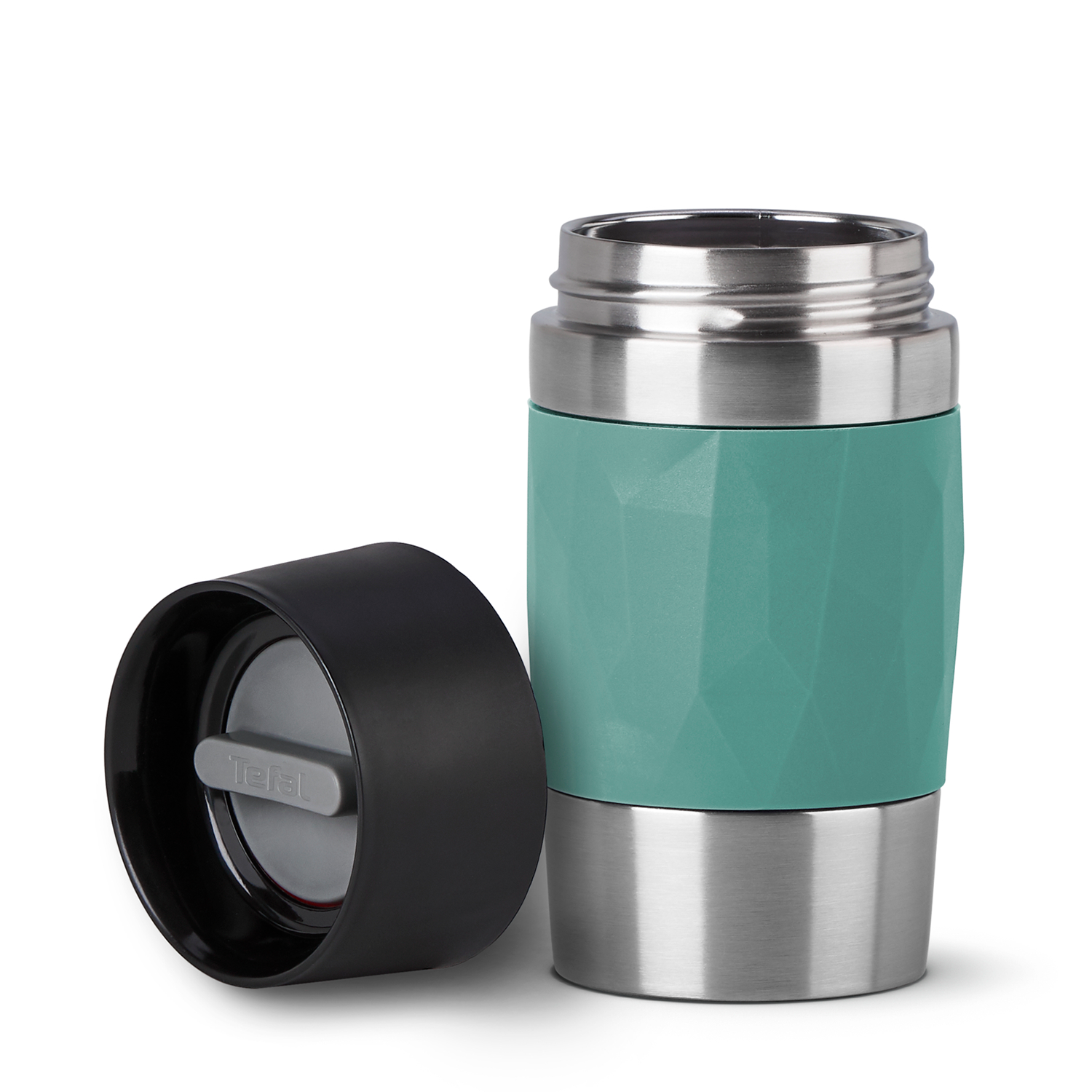A teal and silver travel mug with a black lid is on a white surface. The lid is open next to the mug.