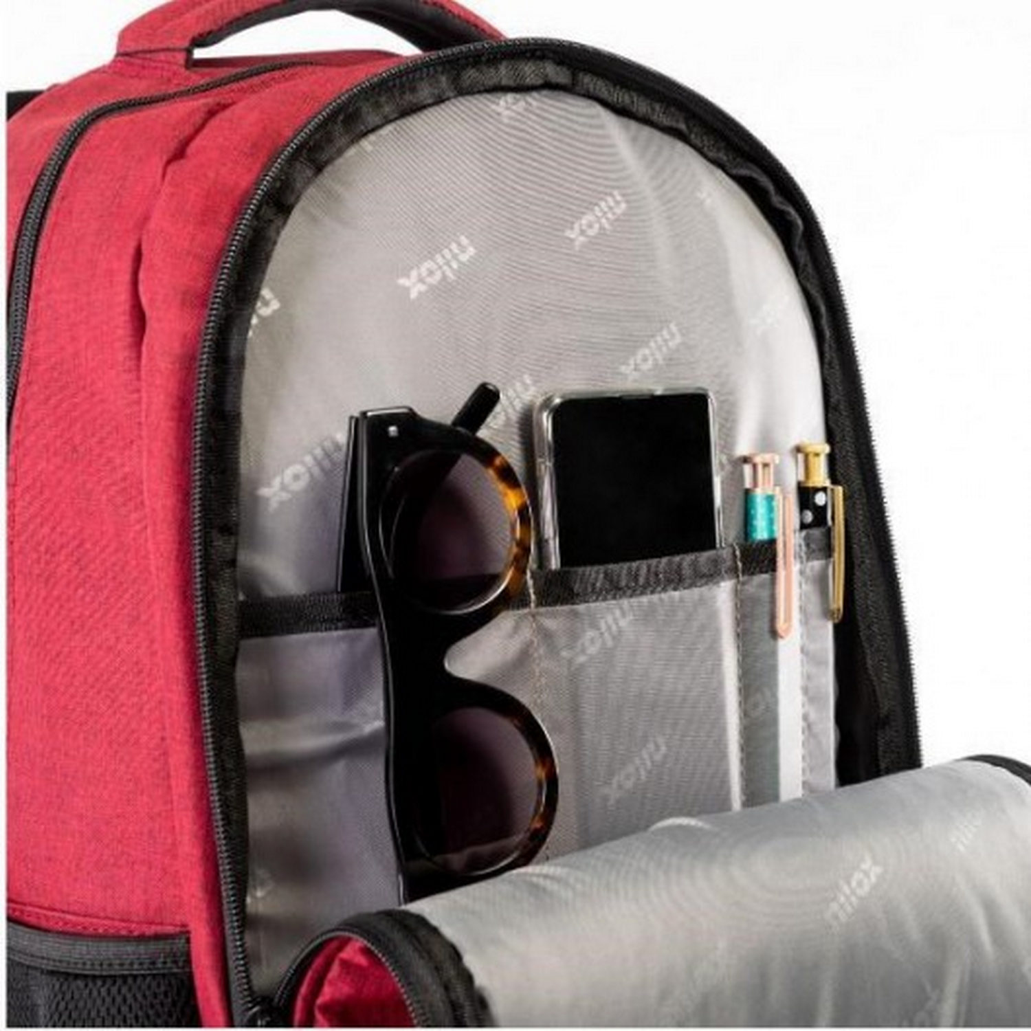 Interior de una mochila roja con gafas de sol, teléfono, bolígrafos y otros objetos en los bolsillos.