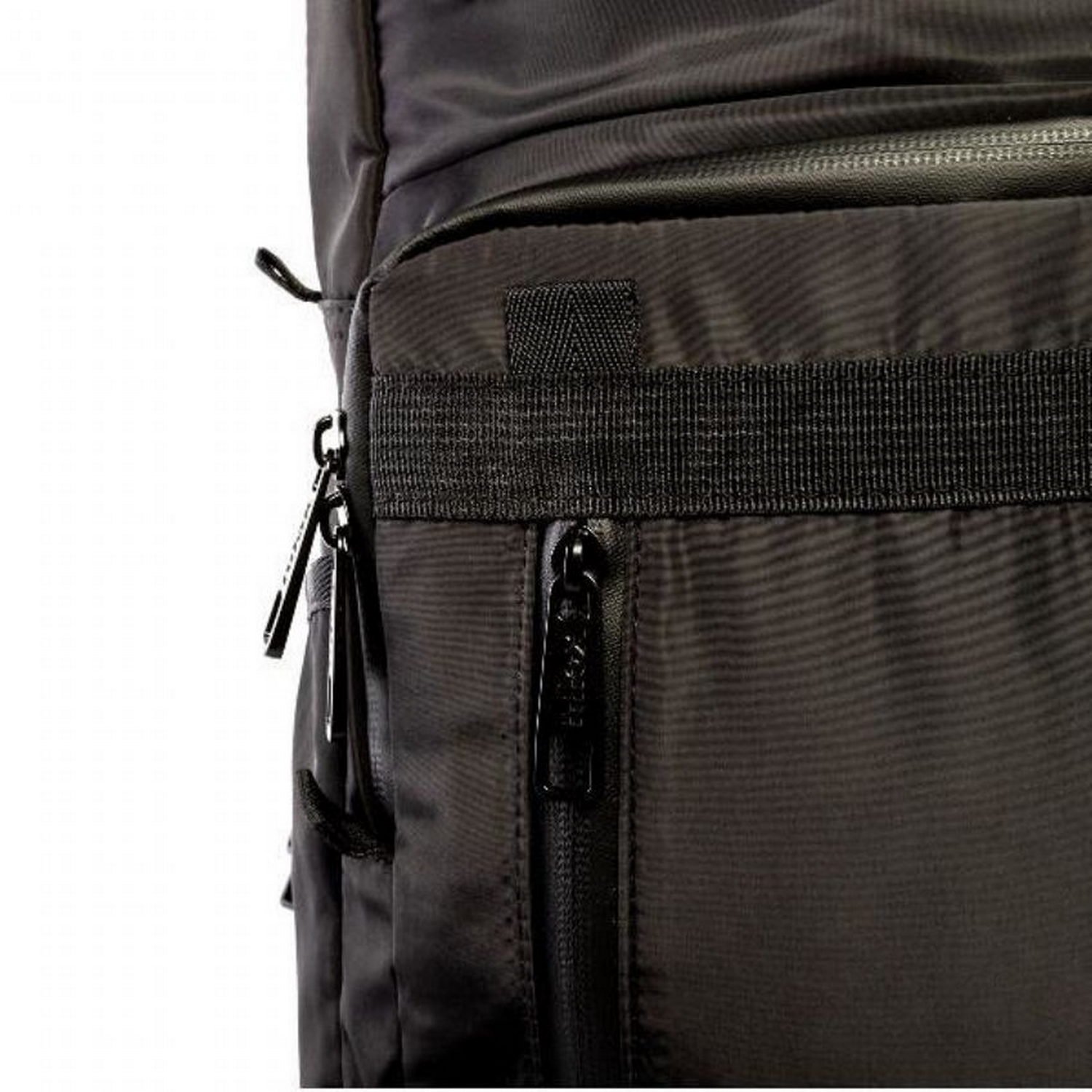 Primer plano de una mochila negra, con cremallera y detalles de correas. Aislado sobre fondo blanco.