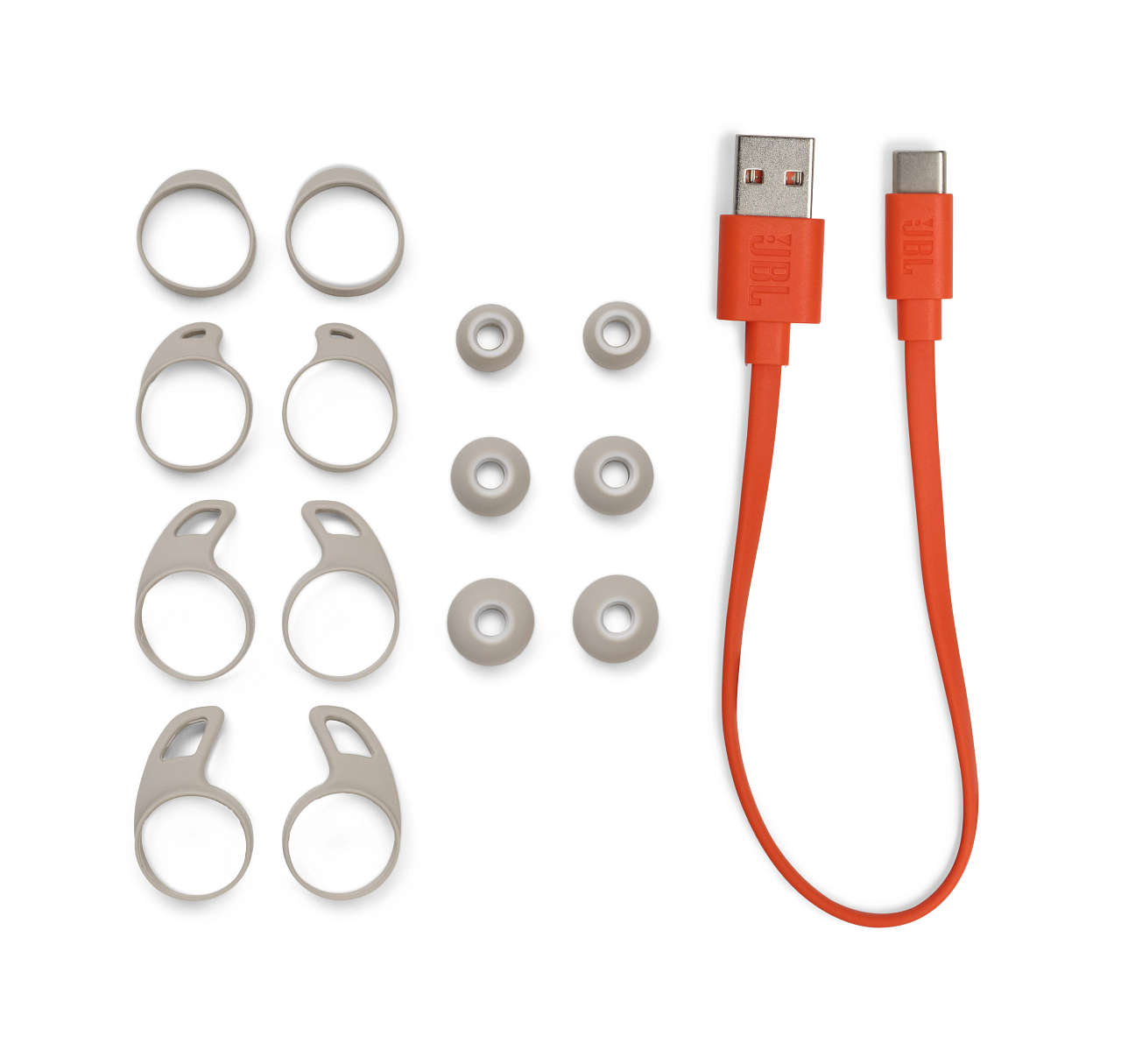 Kopfhörerzubehör, einschließlich Ohrstöpsel und Ohrbügel, sowie ein Ladekabel.