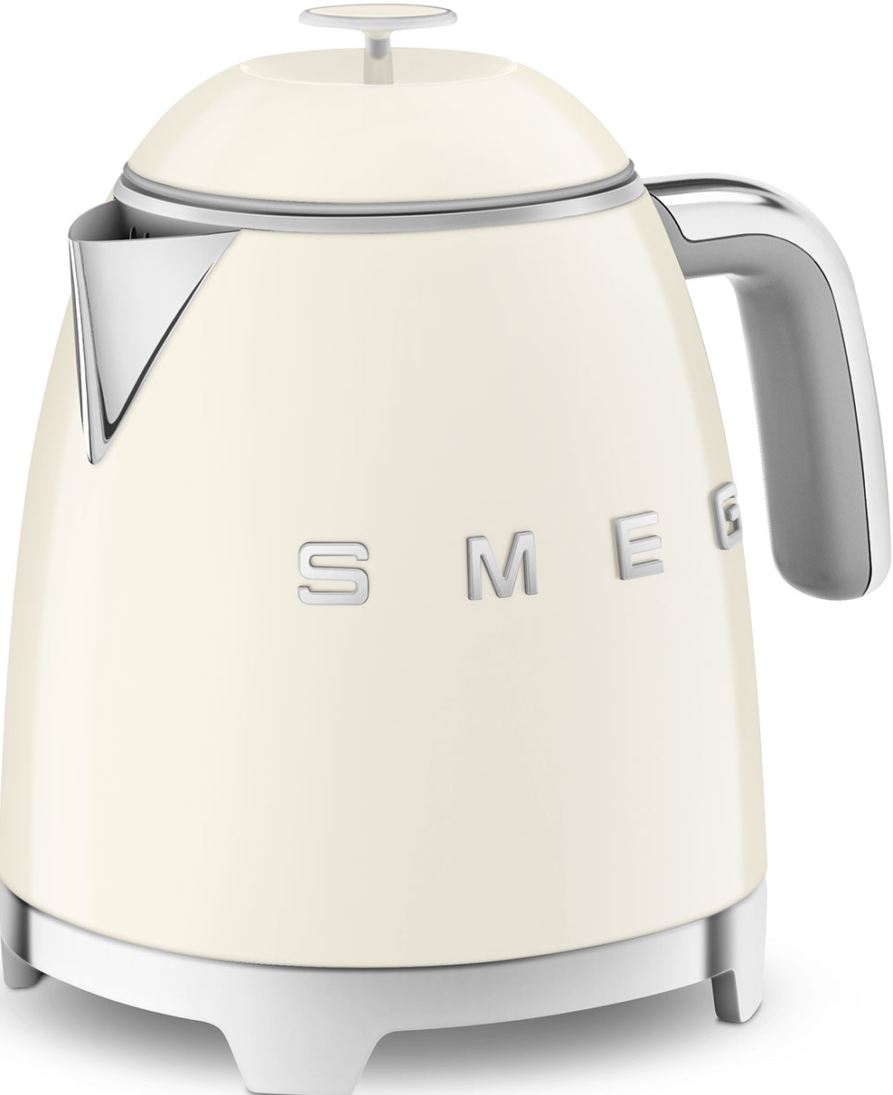 Cremefarbener Smeg-Wasserkocher auf weißem Sockel. Silberner Ausguss und Griff. Klassisches Retro-Design.