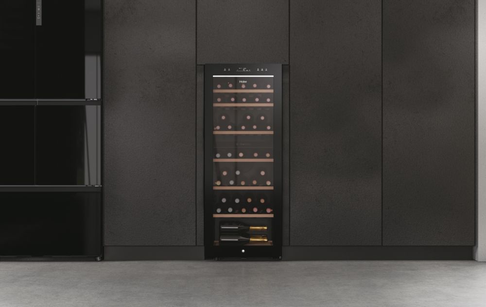 Weinkühler mit vielen Flaschen in dunklem Schrank.