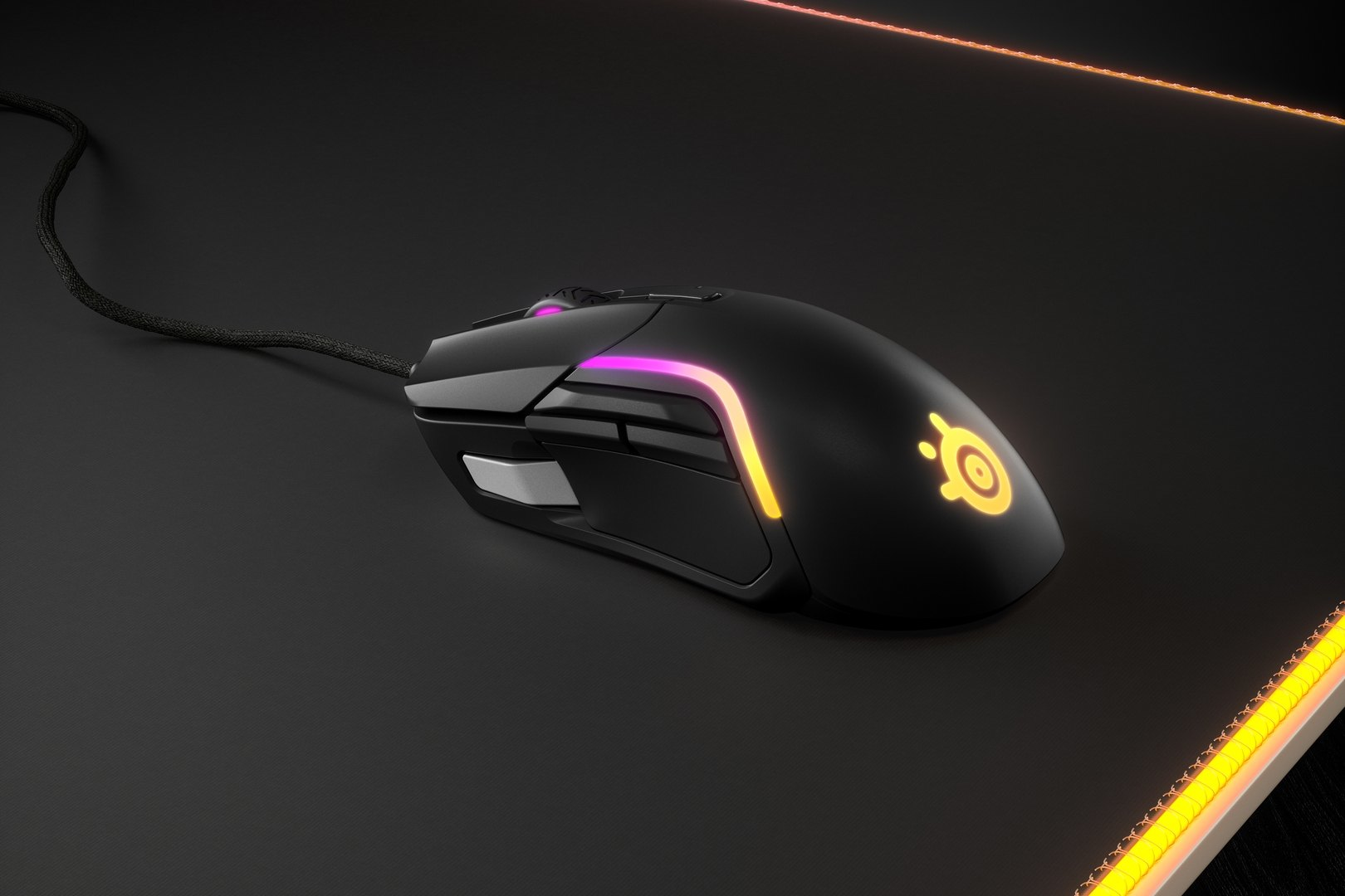Fekete gamer egér megvilágított díszítéssel egy fekete egérpadon.