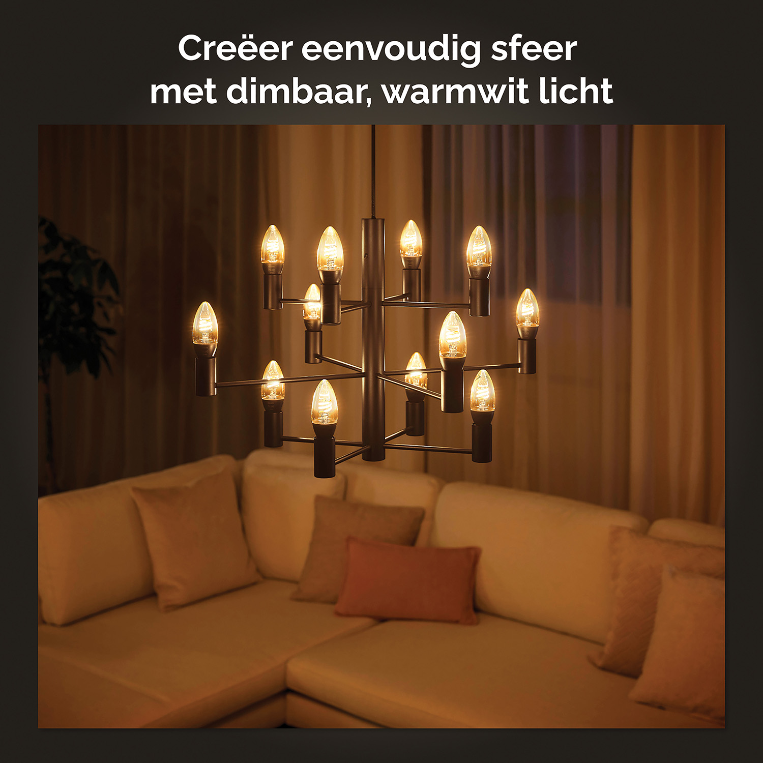Een kroonluchter met veel kleine gloeilampen boven een bank. De kamer is zwak verlicht, wat een gezellige sfeer creëert.