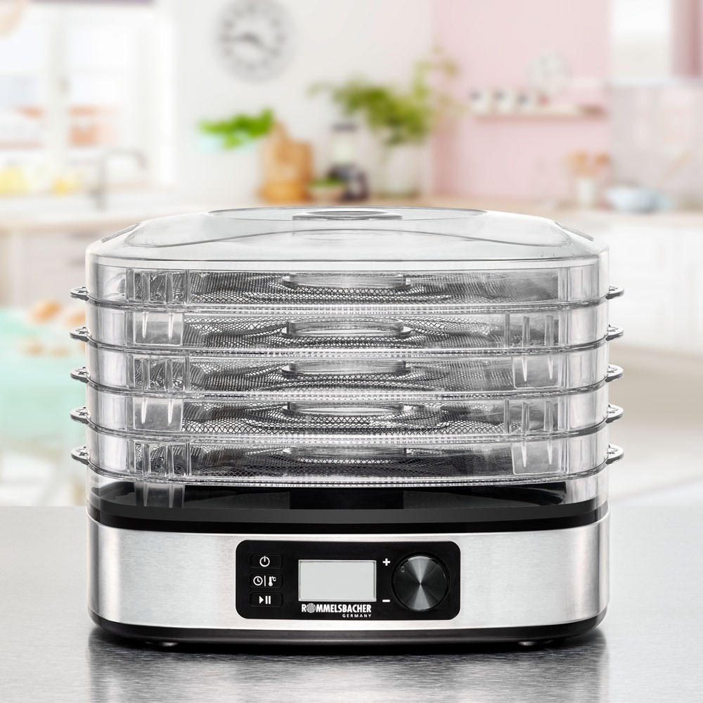 Ein Lebensmittel-Dehydrator mit mehreren transparenten Tabletts und einem digitalen Bedienfeld, drinnen.