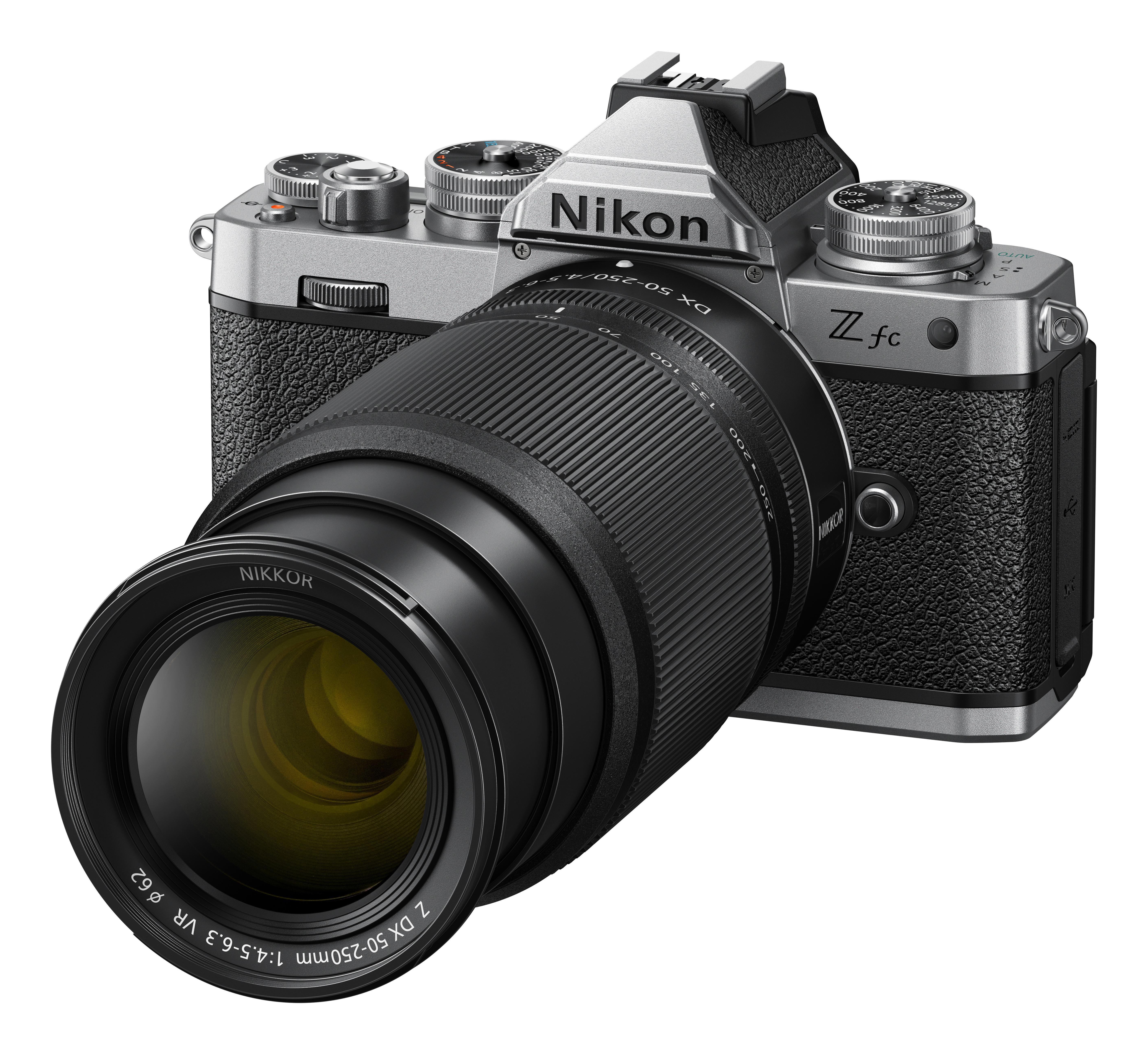 Nikon Z fc Kamera mit Nikkor-Objektiv. Silberne und schwarze Kamera, schwarzes Objektiv, auf weißem Hintergrund.