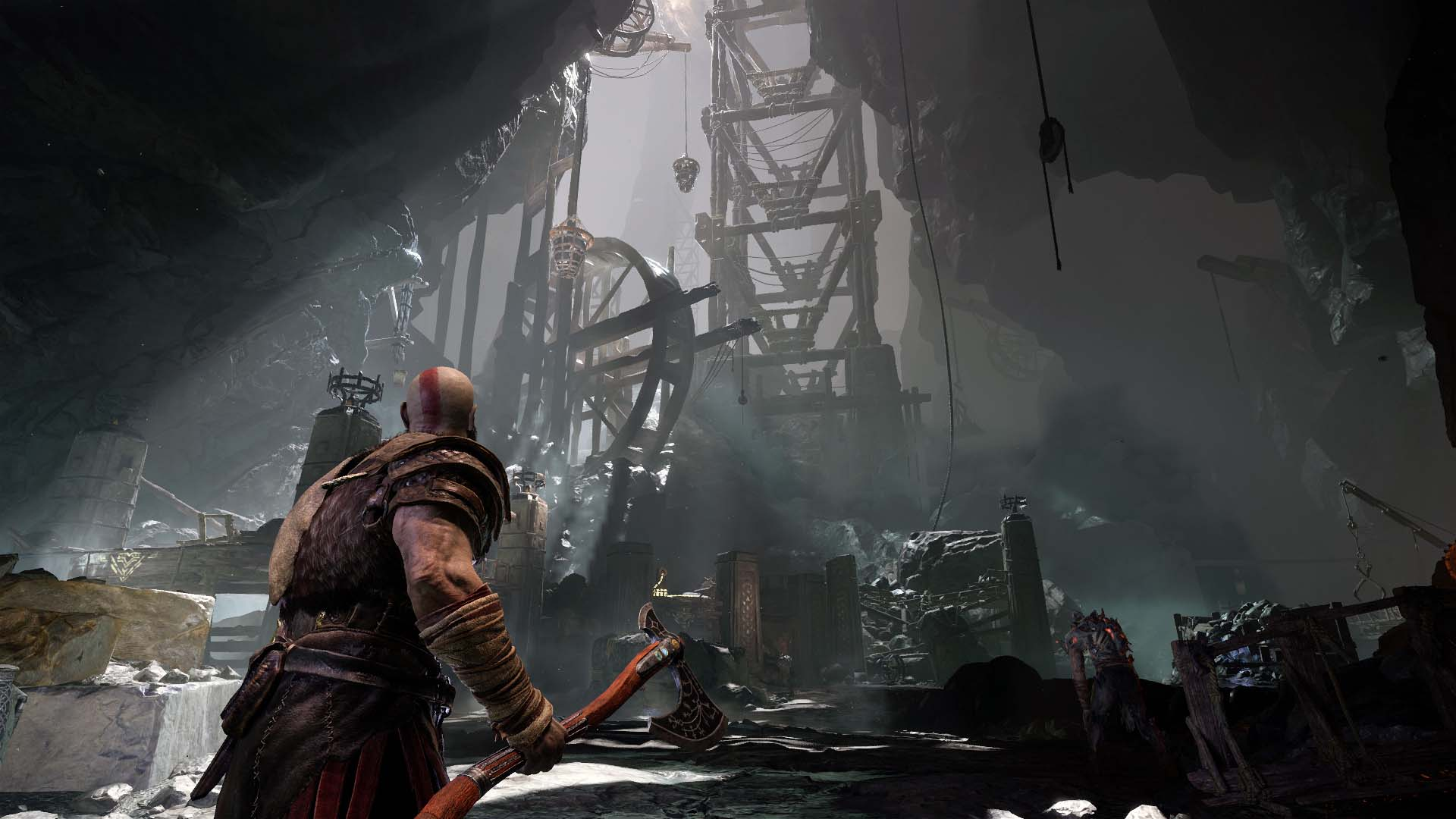 A video game scene with a man holding an axe. Dark cave with structures.