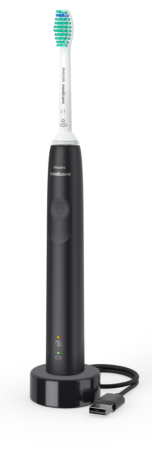 Black electric toothbrush on a black charging base. The brush head is white with green bristles.