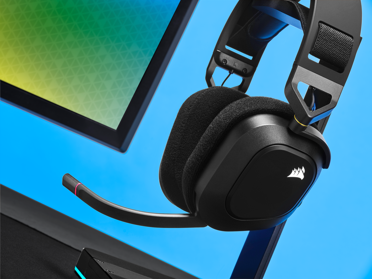 Ein schwarzes Gaming-Headset mit Mikrofon steht auf einem Ständer, vor blauem und schwarzem Hintergrund.