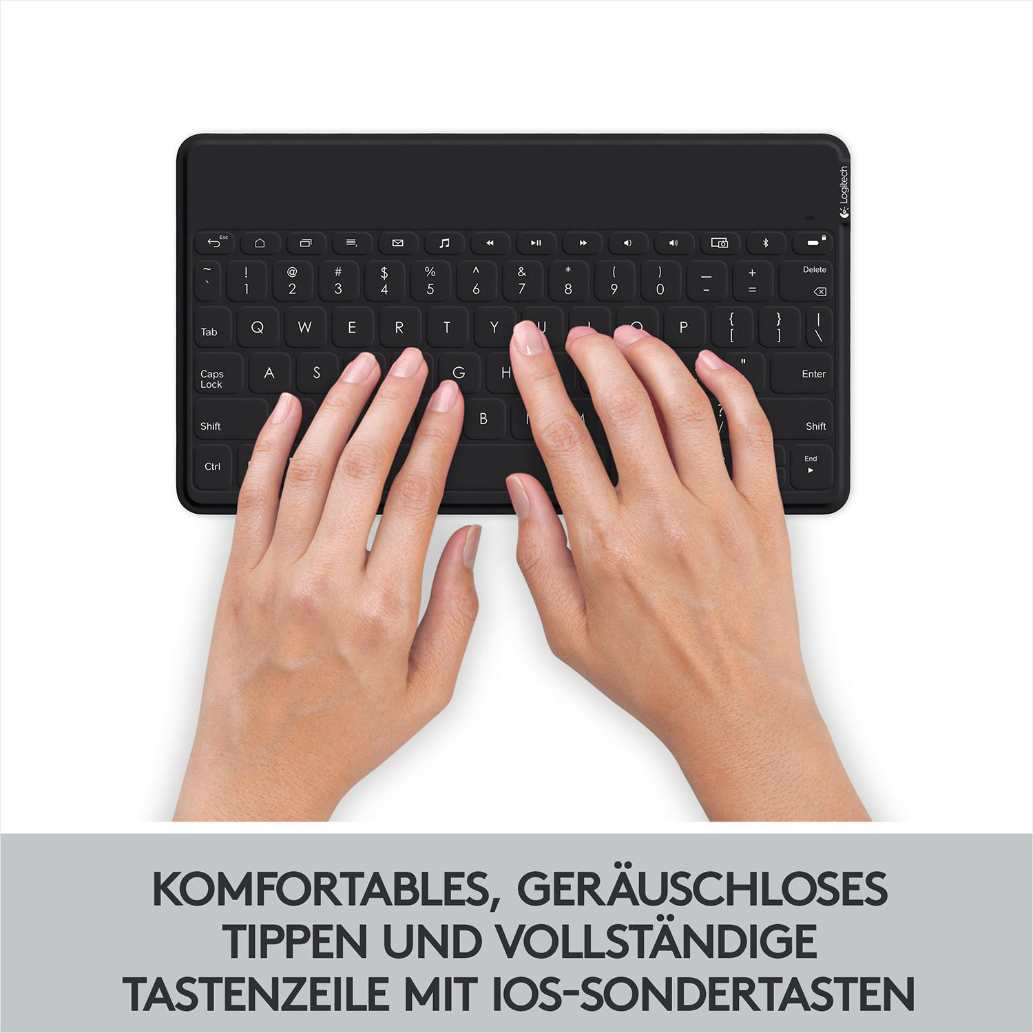 Hände, die auf einer schwarzen Tastatur mit weißen Tastenanschriften tippen, mit Text darunter.