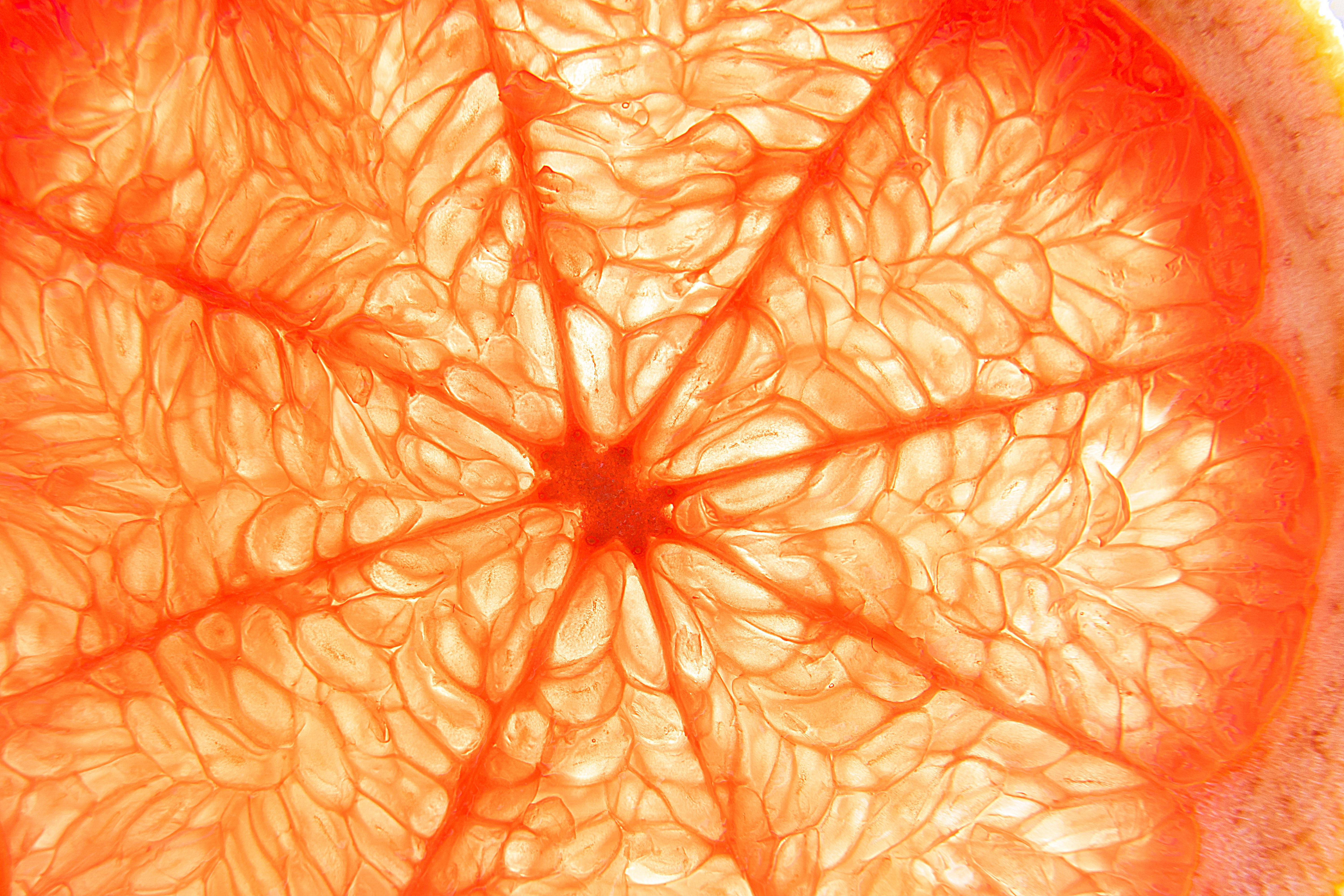 Nahaufnahme einer Grapefruit-Scheibe mit roten und orangen Segmenten.
