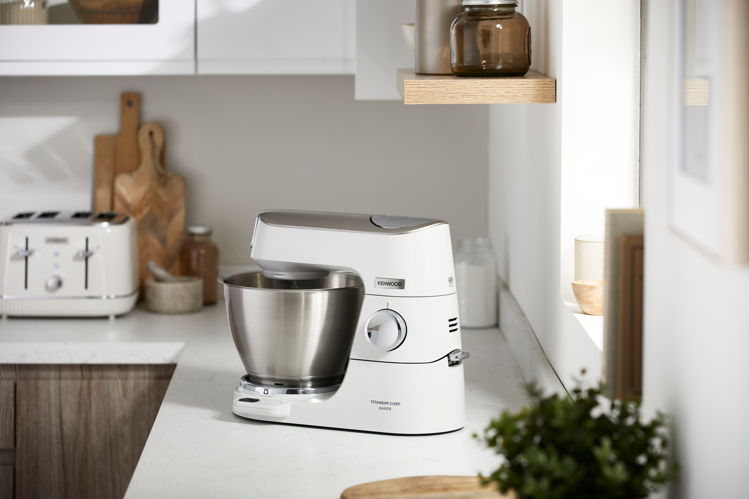 Weiße Küche mit Küchenmaschine auf der Theke und einem Toaster.