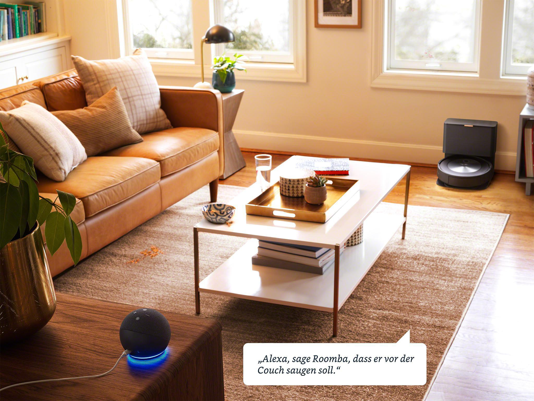 Wohnzimmer mit braunem Ledersofa, Couchtisch und Roomba. Ein Echo Dot liegt auf dem Boden.