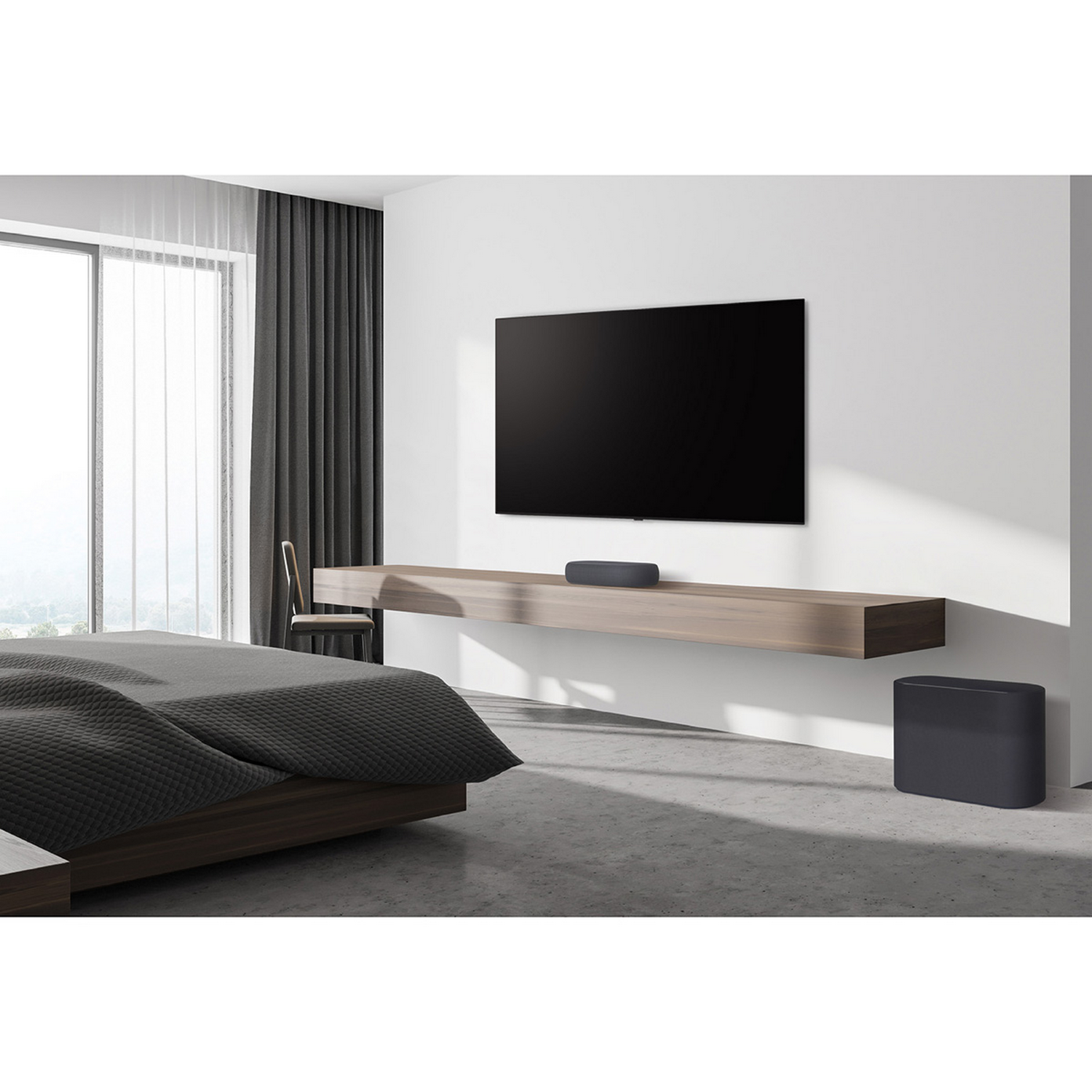 Dormitorio con TV, barra de sonido, silla y subwoofer. Colores gris y blanco.