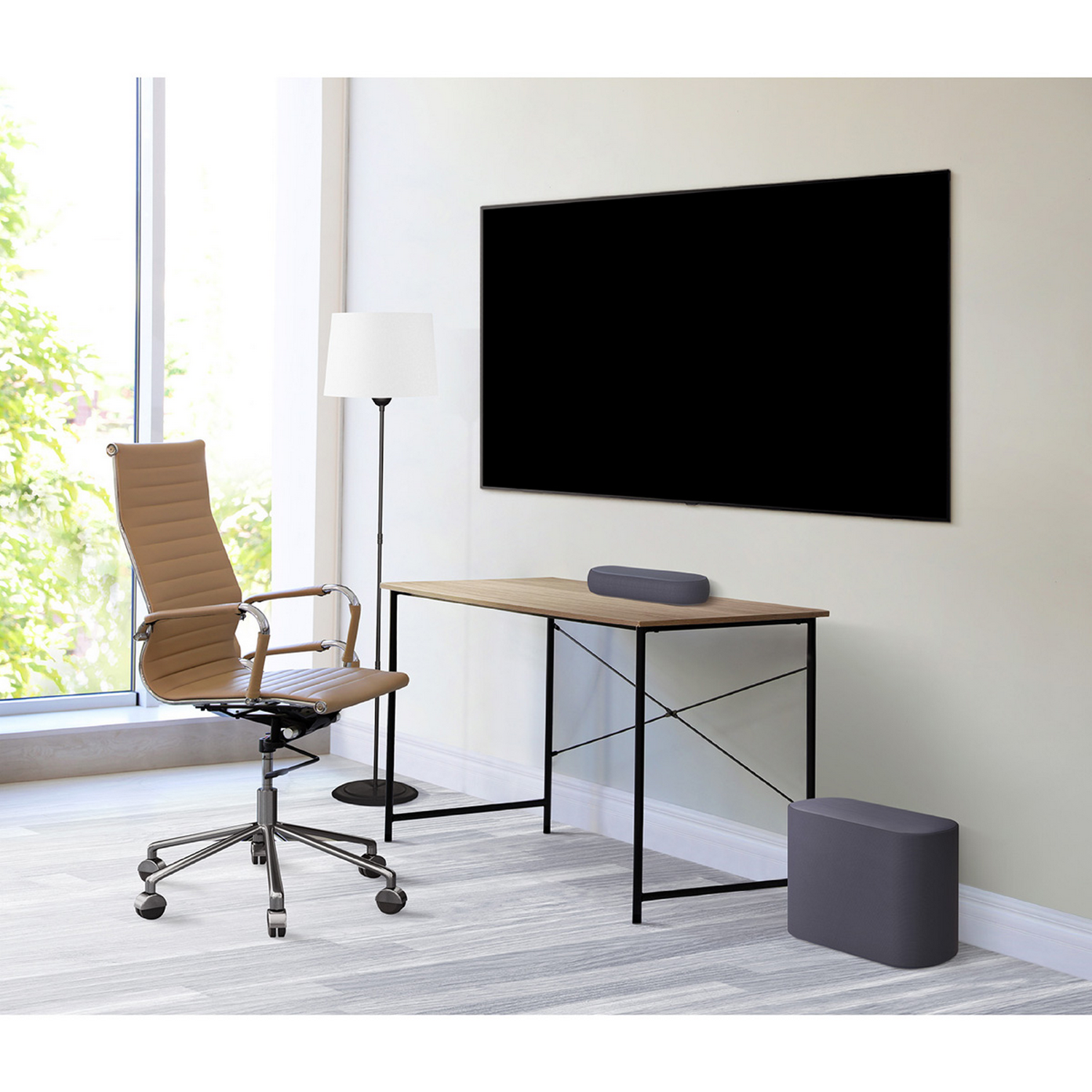 Un entorno de oficina con un escritorio, una silla y una gran pantalla de TV montada en la pared. Hay una barra de sonido en el escritorio.
