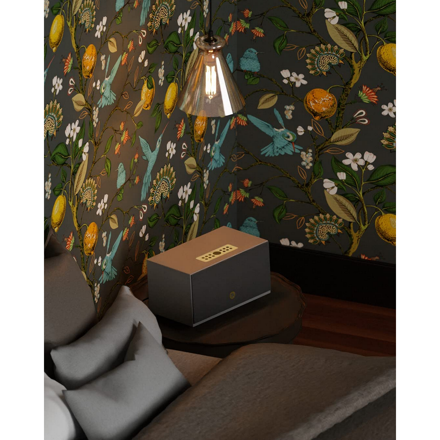 Escena de dormitorio con papel pintado floral, altavoz en mesa, lámpara colgante y cama con almohadas.