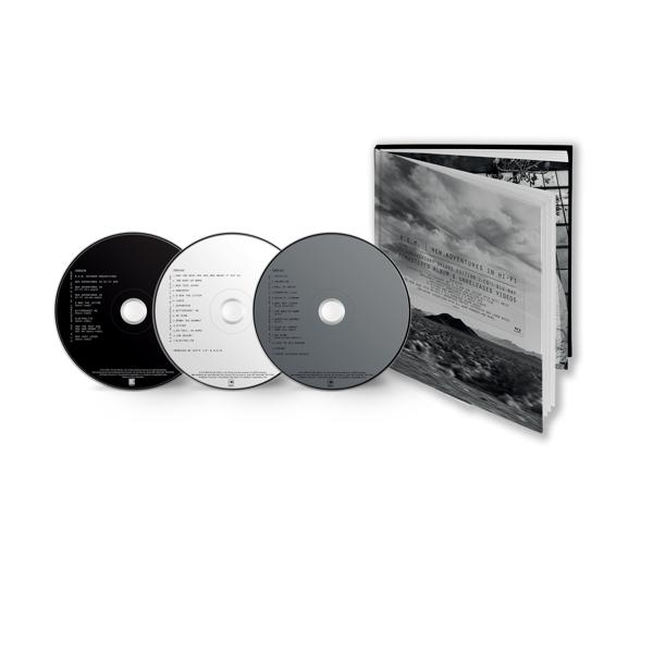 Drie cd's, zwart, wit en grijs, met een boek. Witte achtergrond.