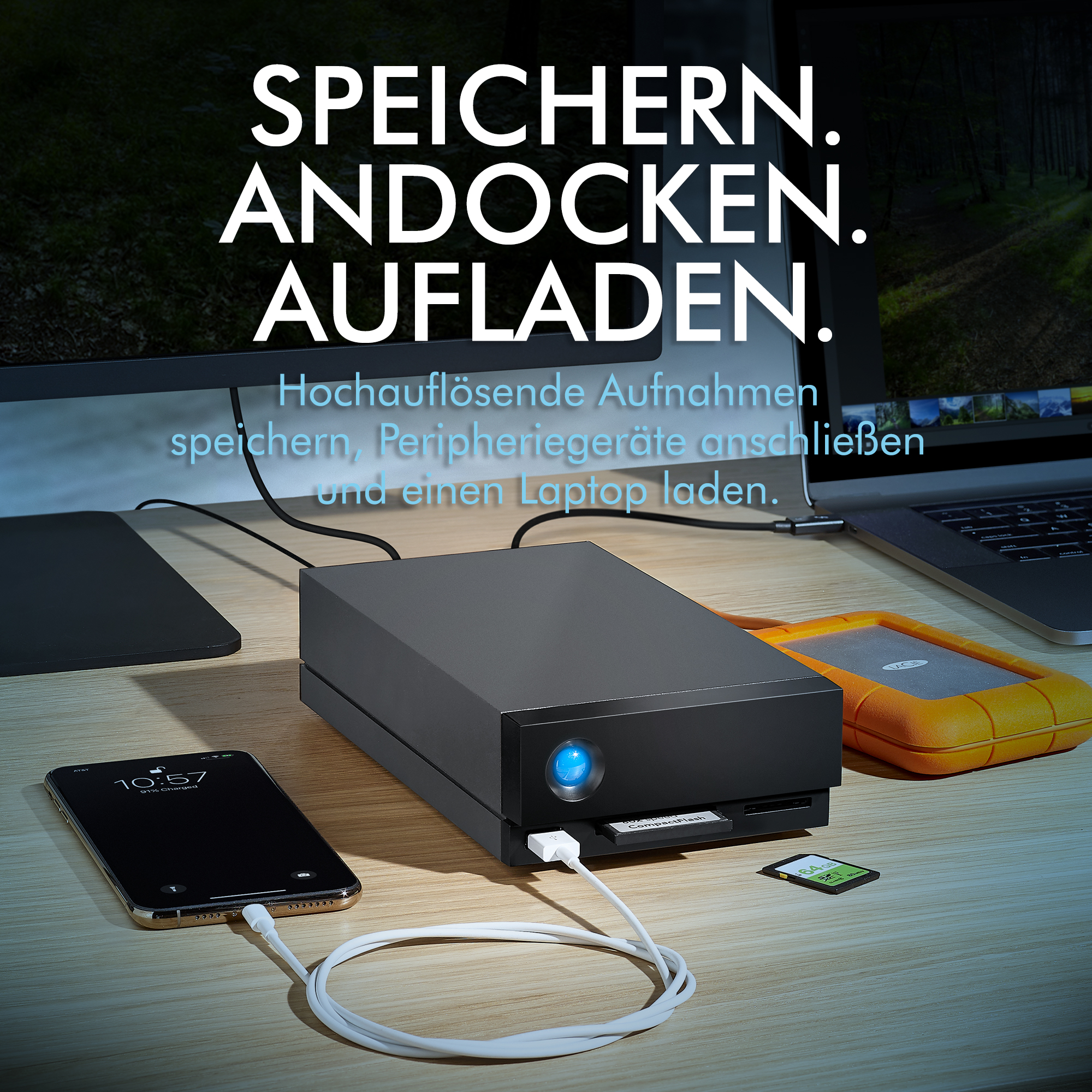 Schwarze und orangefarbene Geräte auf einem Holzschreibtisch. Ein Telefon, eine Festplatte und eine SD-Karte sind sichtbar.