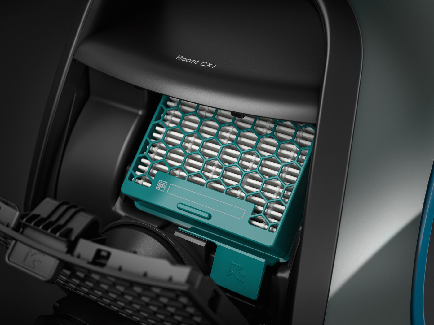 An open vacuum cleaner compartment with a teal filter.