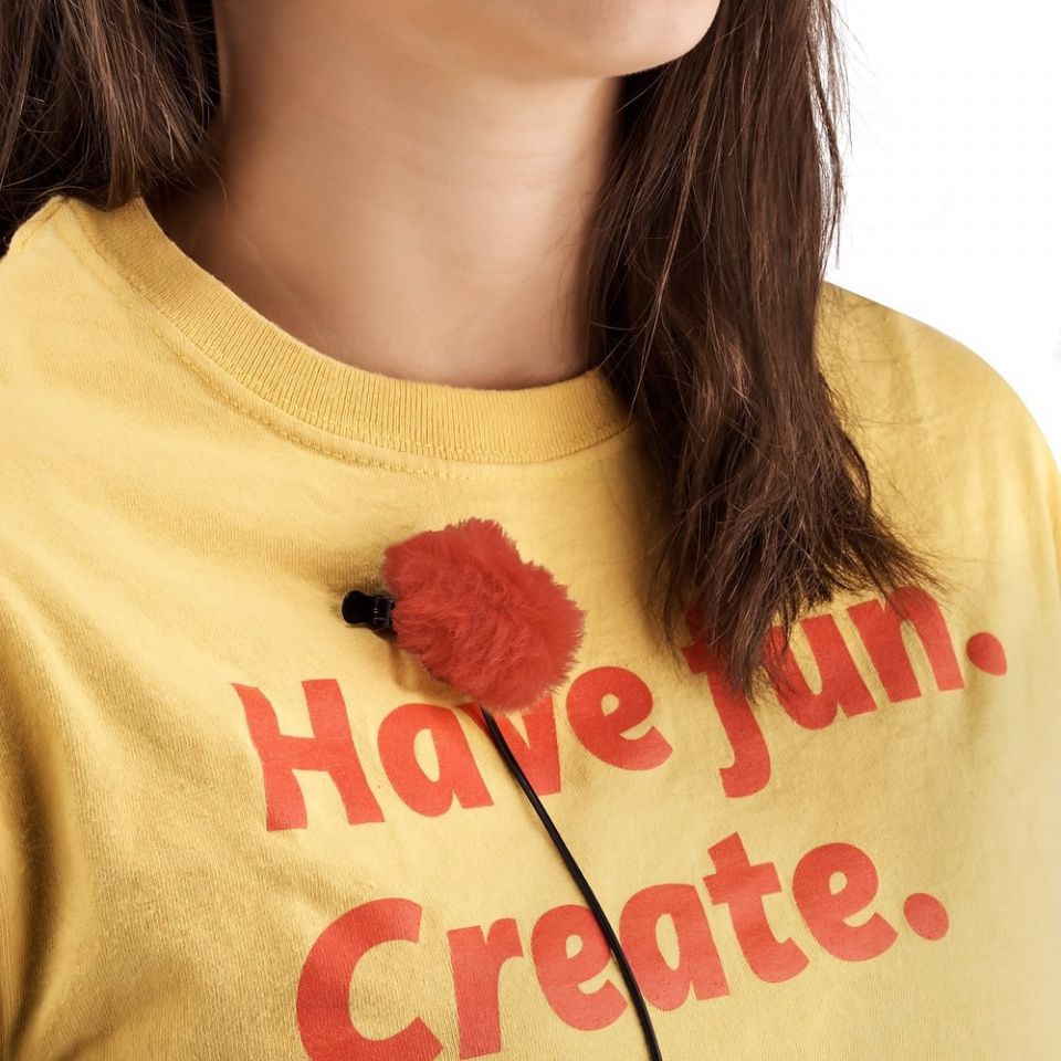 Personne avec un micro sur un t-shirt jaune. Mots rouges, Amusez-vous. Créez.