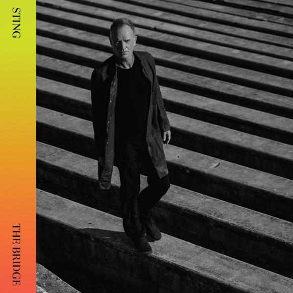 Sting descend des marches en manteau noir. Pochette de l'album The Bridge.