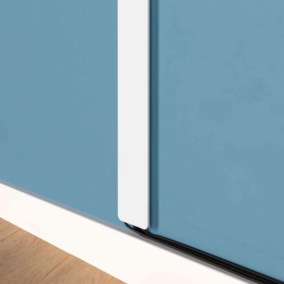 A corner of a room with a white baseboard and a blue wall.