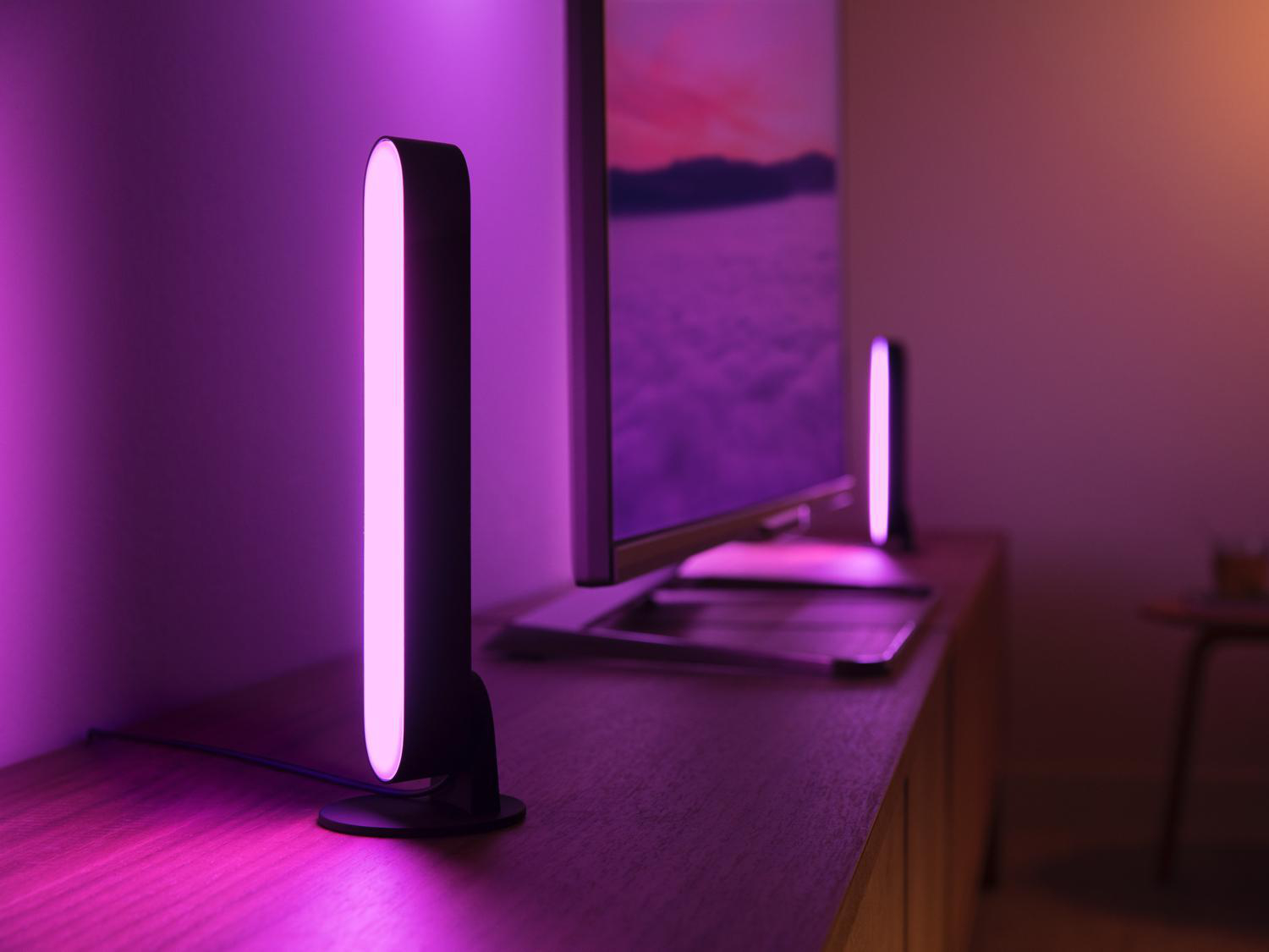 Zwei Lampen auf einer Oberfläche, im Hintergrund ein Fernseher.