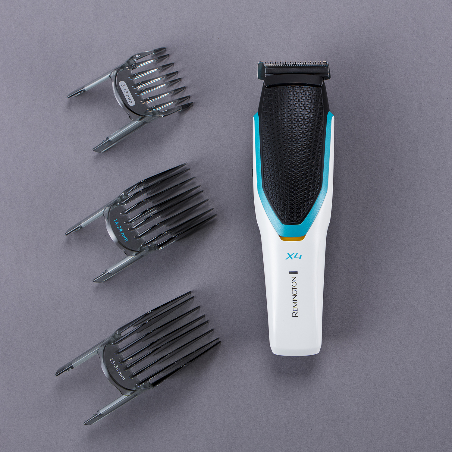 Remington X4 hair trimmer with 3 comb attachments on gray surface.