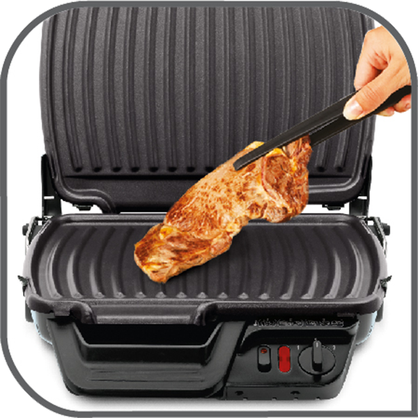 Grill egy darab sült hússal, amelyet csipesszel tartanak.