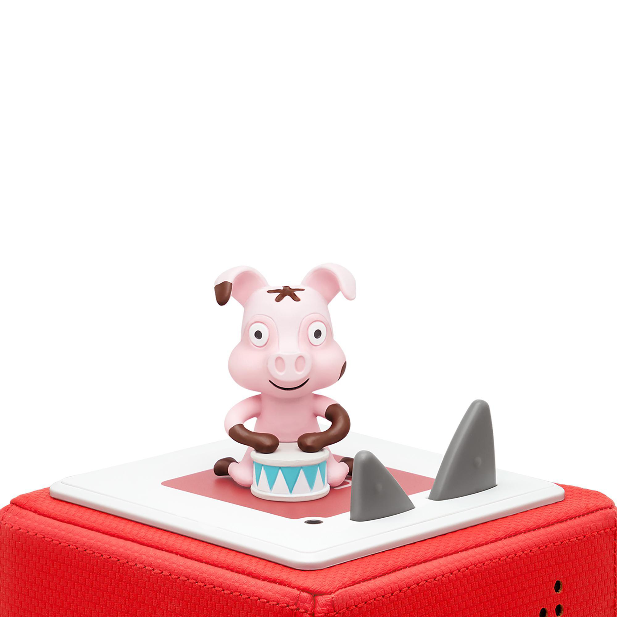 Ein rosa Schweinespielzeug, das Schlagzeug spielt, mit haifischflossenförmigen Elementen auf roter Basis.