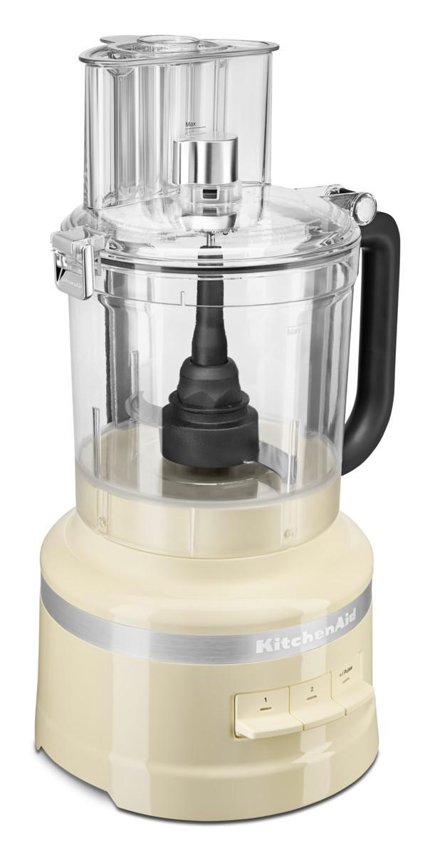 KitchenAid Küchenmaschine, cremefarben, mit durchsichtiger Kunststoffschüssel und schwarzem Griff. Beigefarbene Basis.