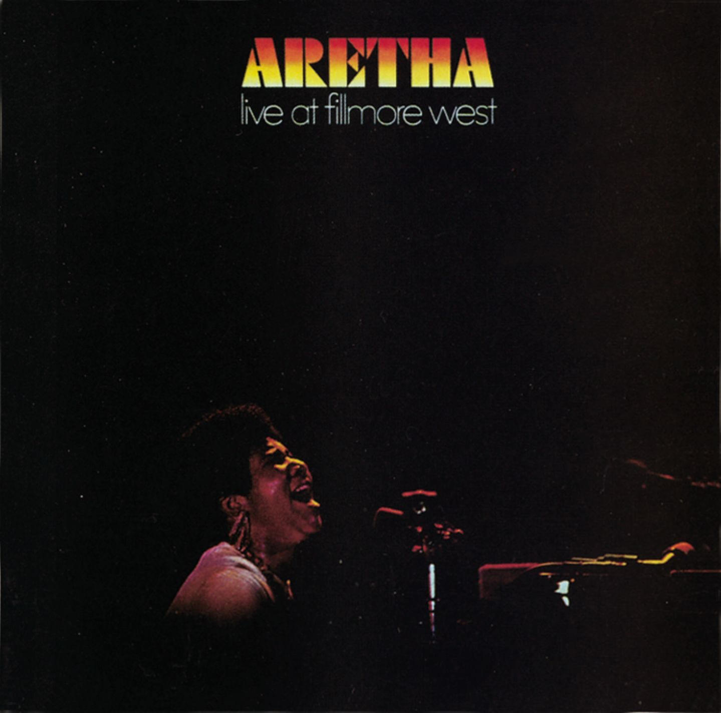 Album borító. Aretha Franklin élőben énekel. Cím: Aretha, live at Fillmore West. Sötét háttér, énekesnő a reflektorfényben.