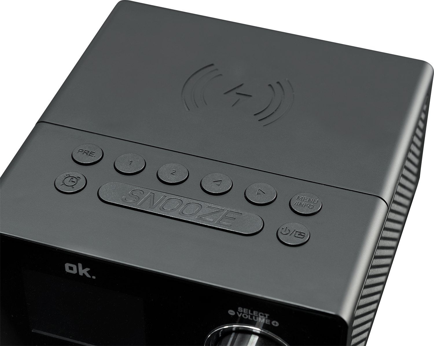 A black ok. alarm clock with snooze and function buttons. Top view, black background.