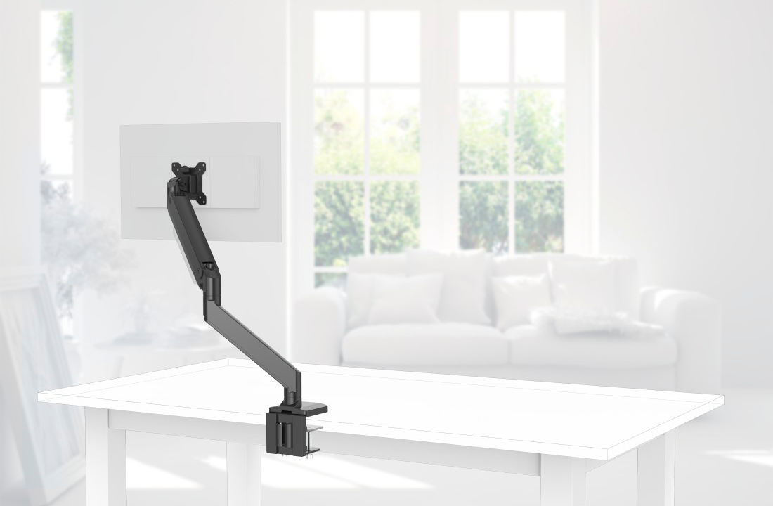 Un bras de moniteur noir est fixé à un bureau blanc avec un moniteur, une pièce en arrière-plan.