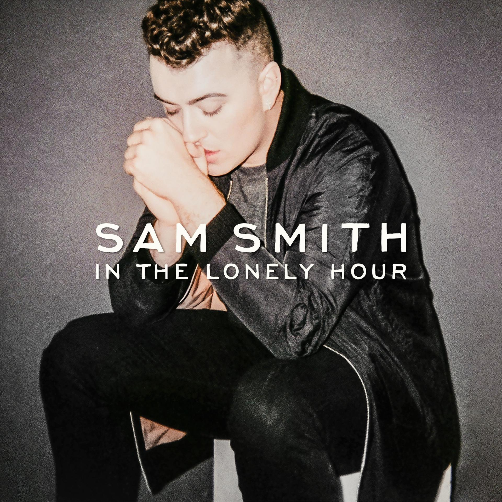 Pochette de l'album de Sam Smith. Il est assis et tient ses mains près de son visage. Fond sombre.