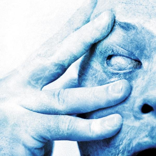 Nahaufnahme eines Gesichts mit Hand, die das Auge bedeckt, in Blautönen.