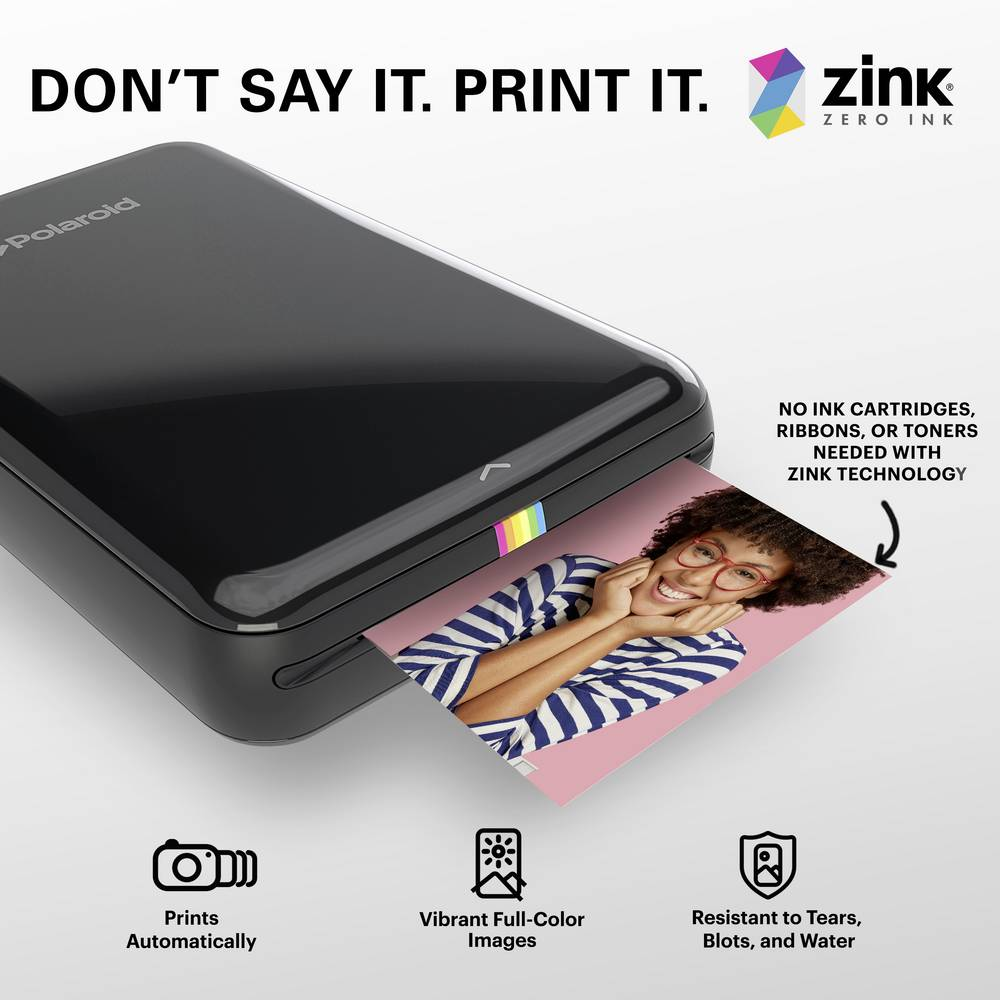 Ein schwarzer Polaroid-Drucker wird gezeigt, wobei ein Foto ausgeworfen wird. Text: Sag es nicht. Druck es aus.