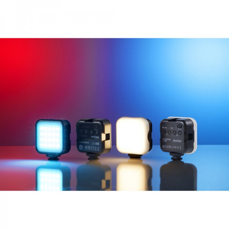 Vier kleine LED-Leuchten in einer Reihe. Sie sind in verschiedenen Farben, blau, weiß und gelb. Roter und blauer Hintergrund.