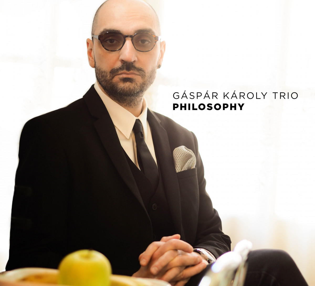 Gáspár Károly Trio album borítója. Szemüveges, fekete öltönyös férfi ül. Zöld alma előtt.