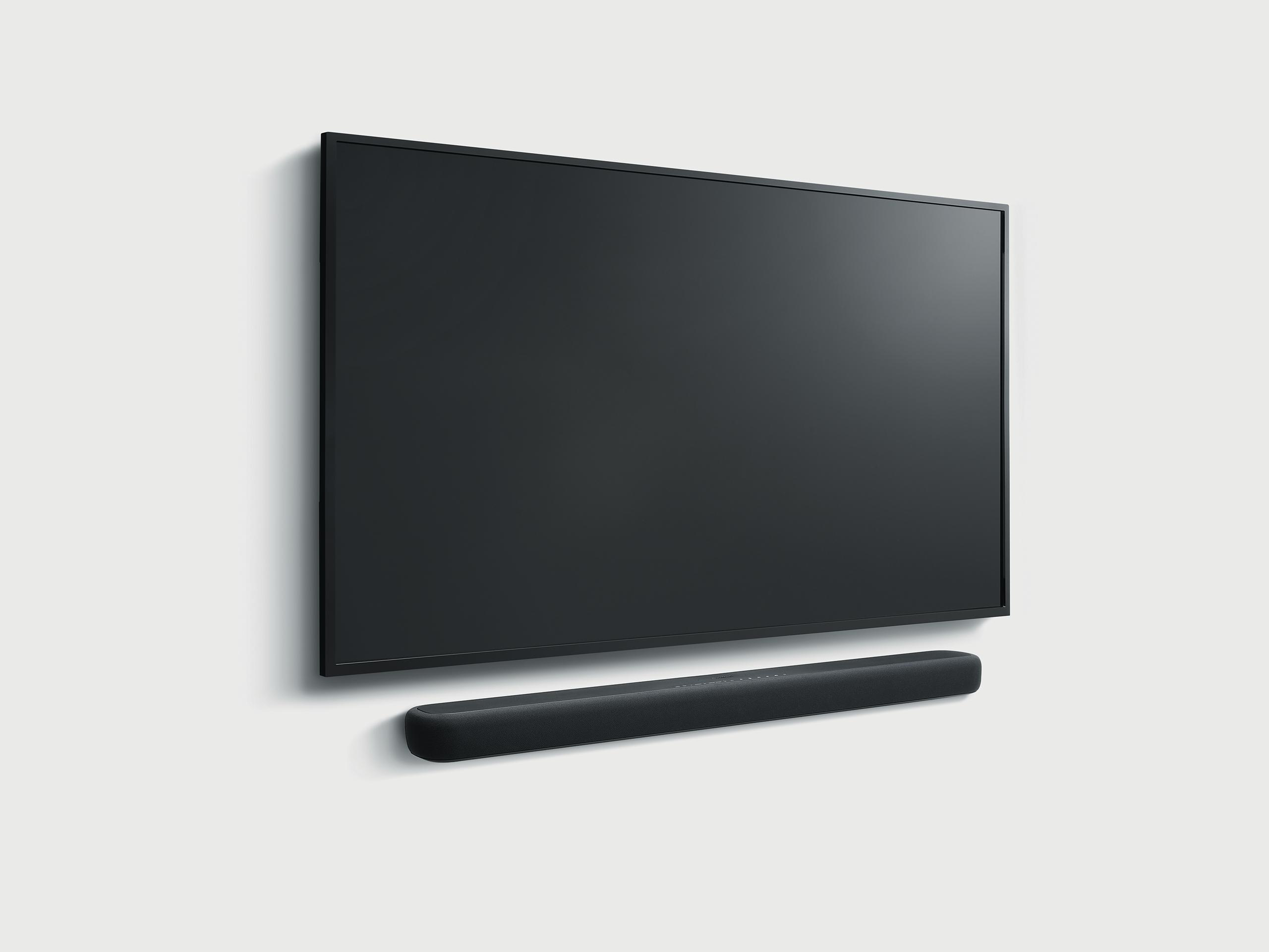 Ein schwarzer Fernseher und eine Soundbar, montiert an einer weißen Wand.